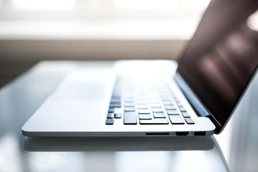 Free Elegant side view of a laptop on a glossy table with natural lighting indoors. Stock Photo